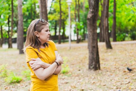 Scared young woman lost in the forest looking for a way out - Beautiful confused girl with brown hair and summer outfit walking alone in the woods while looking in the distanceの写真素材