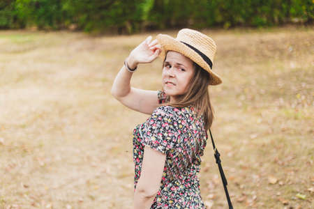 Person looking over the shoulder - Straw hat on a girl that is watching behind her - Woman turning aroundの写真素材