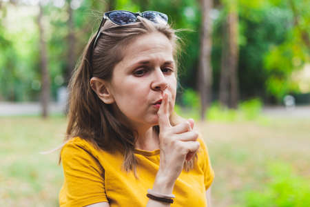 Finger on lips silence gesture made by a secret person outside - Mystery teenage making silence sign with handの写真素材