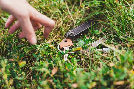 Close hand to some lost keys in the grass - Someone discovering some forgotten personal home itemsの写真素材
