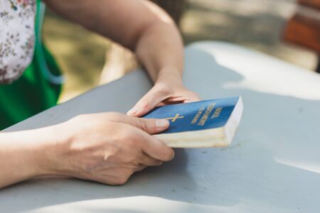 Young person holding a small Bible outside on a summer day â€“ Girl with Holy Book praying...