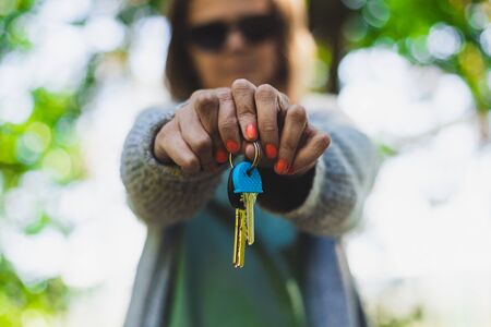 Landlord tenant giving the keys - Concept of real estate agent or woman selling, renting or buying a new homeの写真素材