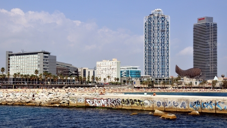 Barcelona, Spain - September 11, 2012: Crowded beach of Barcelona at the midday in Sunny Day. View at the Skycrapers from the sea.のeditorial素材