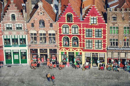 BRUGES, BELGIUM - MARCH 8, 2014: Famous old colorful buildings at Markt (Market) square with locals and tourists sitting in cafes. Popular Flemish city with almost intact medieval architecture.のeditorial素材