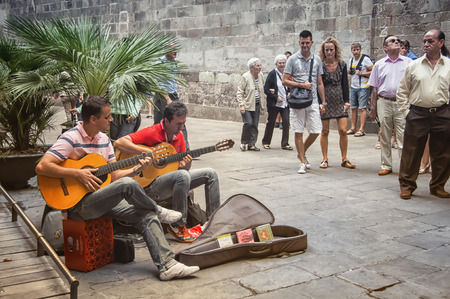 BARCELONA, SPAIN - SEPTEMBER 15, 2013: Close view of street musicians and people watching them in Ciutat Vella - Old town. Musicians playing guitarsのeditorial素材
