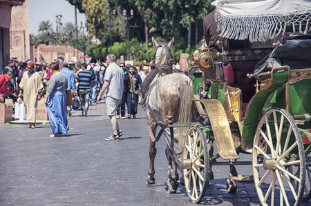 MARRAKESH, MOROCCO - MAY 25, 2014: Horse carriage at the famous Djemaa El-Fna square in the Medina. Blurred people at the background. Popular touristic attractionのeditorial素材