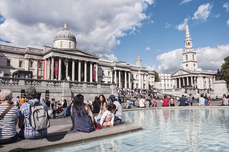 LONDON - AUGUST 31, 2014: Trafalgar square crowded with people. It is a popular touristic attraction which commemorates the Battle of Trafalgar and hosts different monuments and statuesのeditorial素材
