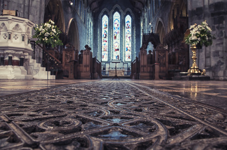 KILKENNY, IRELAND - NOVEMBER 22, 2014: Interior of St Canice's Cathedral which dates from 13th century. Blurred photo with focus on the iron bars on the floorのeditorial素材