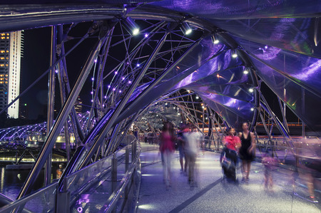 SINGAPORE - MAY 17, 2014: Night view of Helix pedestrian bridge in Marina Bay in Singapore. It is a part of the walkway around Marina Bay. Blurred people walking inside.のeditorial素材