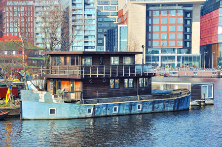 Old rusty wooden boat moored in Amsterdam, Netherlandsの写真素材