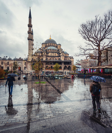 Rainy day in Istanbul, Turkey. People with umbrellas in front of New Mosqueの写真素材