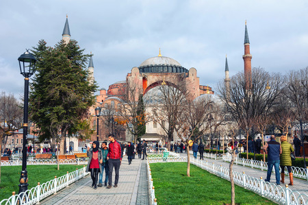 ISTANBUL, TURKEY - DECEMBER 13, 2014: People in Sultanahmet Park with Hagia Sophia mosque at the background. Tourists walking around in a cloudy winter day. Famous landmark in the cityのeditorial素材