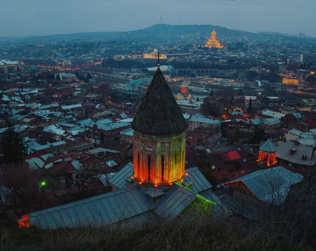 Aerial view of Tbilisi, Georgia city center at night. With Holy Trinity Cathedral at the background...