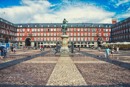 MADRID, SPAIN - JULY 22, 2015: Plaza Mayor with people - a central square in the city. The bronze statue of King Philip III in the middle, created in 1616. Famous landmark, toningのeditorial素材