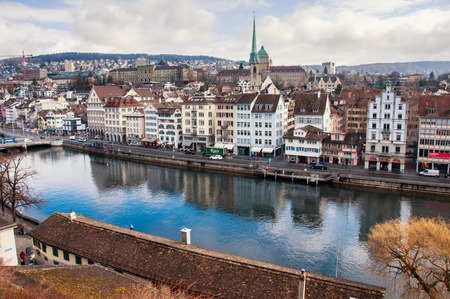 ZURICH, SWITZERLAND - FEBRUARY 27, 2014: Aerial view of old buildings in the city center of with Limmat river. Popular restaurants, cafes and shops. Car traffic and cloudy skyのeditorial素材