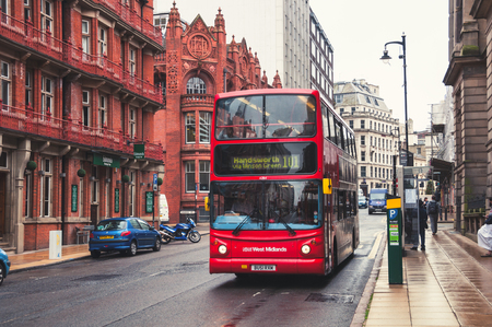 BIRMINGHAM, UK - SEPTEMBER 1, 2014: Red double-decker bus at the street. Old building of the historical part of the city. People, cars and famous restaurants and pubsのeditorial素材