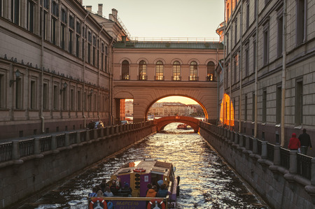 SAINT PETERSBURG, RUSSIA - AUGUST 4, 2015: Touristic boats going down the Winter canal to the Neva river at late evening with sunset sky. It is a popular trip in the cityのeditorial素材