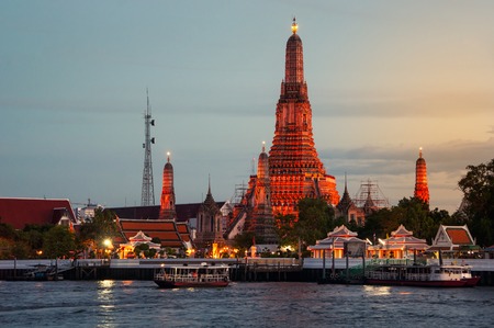 Night view of illuminated famous Wat Arun Temple in Bangkok, Thailand. Sunset colorful sky and...
