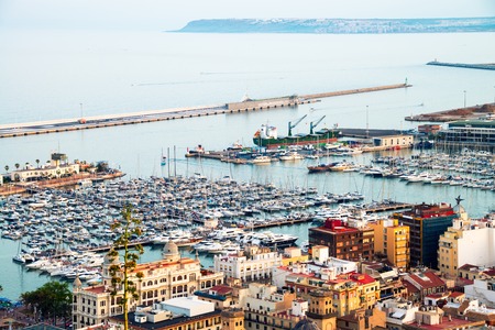 Alicante harbor, Costa Blanca, Spain - popular mediterranean summer resort. Yachts and hotels at the background with famous mountains in the morningの写真素材