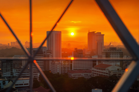 Sunset over Kuala Lumpur skyscrapers, Malaysia. Aerial view of the city center through metallic barsのeditorial素材