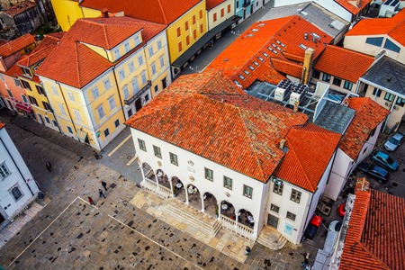 Central square of coastal town Koper in Slovenia seen from above. Historical buildings with red roofs, cafes, shops and restaurantsの写真素材