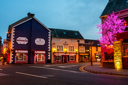 ENNIS, IRELAND - SEPTEMBER 12, 2014: Nightlife at the medieval old part of the popular touristic city in Mid-West Region. It hosts many restaurants and bars, blurry people at the streetのeditorial素材