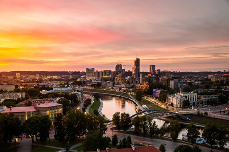 Aerial view of Vilnius, Lithuania at sunset. Modern city with many skyscrapers and car traffic lights, river and colorful sunset skyの写真素材