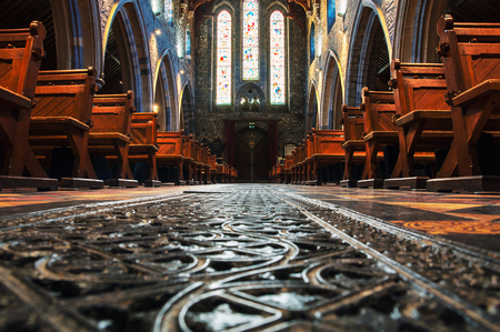 KILKENNY, IRELAND - NOVEMBER 22, 2014: Interior of St Canice's Cathedral which dates from 13th century. Blurred photo with focus on the iron bars on the window and rowsのeditorial素材