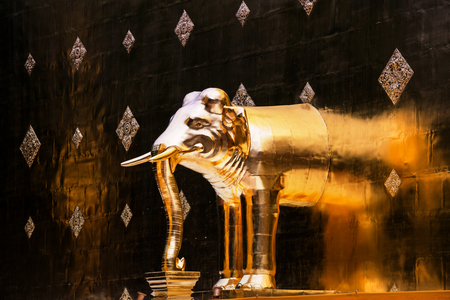 Chiang Mai, Thailand. Golden elephant sculptures of Phra Singh temple in Chiang Mai, Thailand. Golden wall backgroundの写真素材