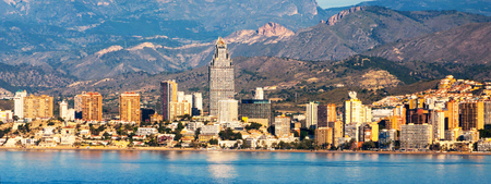 Benidorm, Costa Blanca - a coastal town and popular touristic resort in province of Alicante, Spain. Aerial view of city skyline formed by tall hotels and apartment buildings and mountainsの写真素材