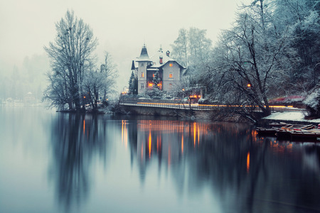 Bled, Slovenia. Foggy morning in Bled lake with a boat and house in Slovenia. Fog over the forest. Famous place in the mountainsの写真素材