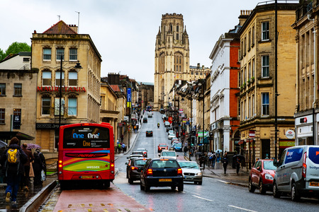 BRISTOL, UK - MAY 17, 2017: Famous street in the center of Bristol, UK during the rainy day. Bright cloudy sky. Various shops, cafes and restaurants. Car and bus trafficのeditorial素材