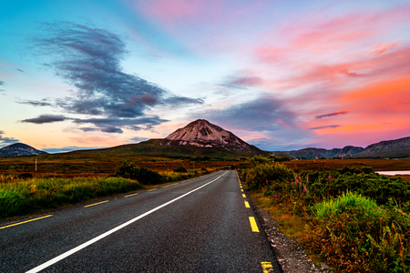 Mountain Errigal in Donegal county, Ireland in the evening at sunset with highway and colorful skyの写真素材