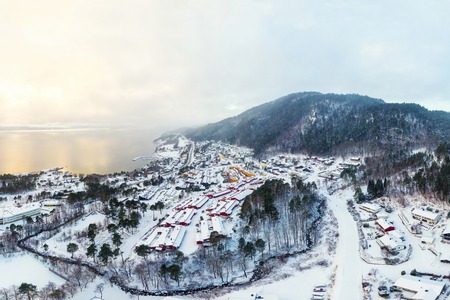 Molde, Norway. Aerial view of residential area in Molde, Norway during a cloudy day in winter. Beautiful fjord with mountains covered in snowの写真素材