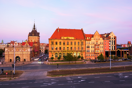 Gdansk, Poland. Sunset view of Brama Wyzynna and other historical buildings in Gdansk, Poland. Car traffic trail with colorful sunset sky.の写真素材