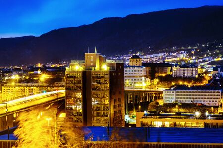View of Bergen, Norway at night. Colorful cloudy blue sky over the mountainsの写真素材
