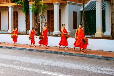 LUANG PRABANG, LAOS - JULY 27, 2016: Alms giving in the morning when monks walk by the streets for the food. Young monks in Luang Prabang, Laosのeditorial素材