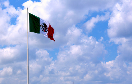 Mexican flag among cloudsの写真素材