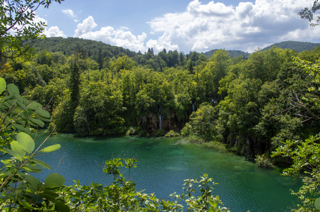 Landscape in Plitvice with green trees, a blue lake and a blue sky with clouds on a sunny day.の写真素材