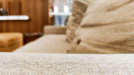 Abstract blurred background of a cream colored long sofa