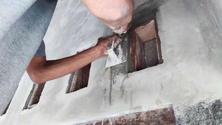 the process of plastering a wall ventilator above the doorの写真素材