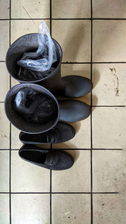 A pair of boots and flat shoes are on the dirty floor. Shoot from high angleの写真素材