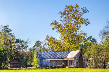 An old abandoned white house with a tin roof in the Country