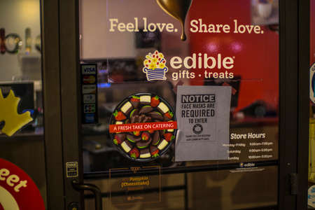 Augusta, Ga USA - 11 22 20: Edibles Gift and Treats retail store at night covid-19 sign in window