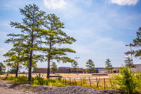 Augusta, Ga USA - 07 04 20: Abandoned Regency shopping Mall corner building view from a distance and fenceのeditorial素材