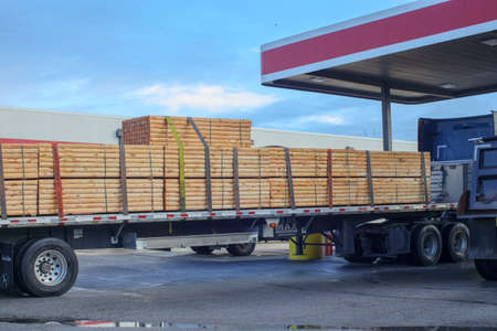 Richmond County, Ga USA - 03 03 21: A fully loaded log truck at a diesel gas station pumpのeditorial素材