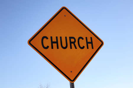 View of a yellow church street sign and clear blue skyの写真素材