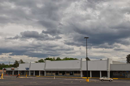 Augusta, Ga USA - 04 15 21: Empty retail shopping plaza buildings a person cleaning the parking lotのeditorial素材