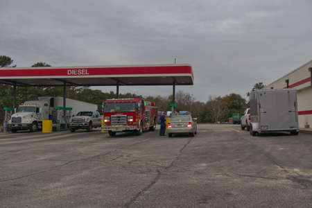 Augusta, Ga USA - 03 01 21: Fire department truck at a diesel gas pump and fireman