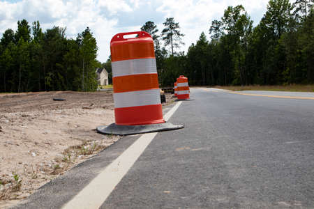 Orange and white large cones on the side of the road